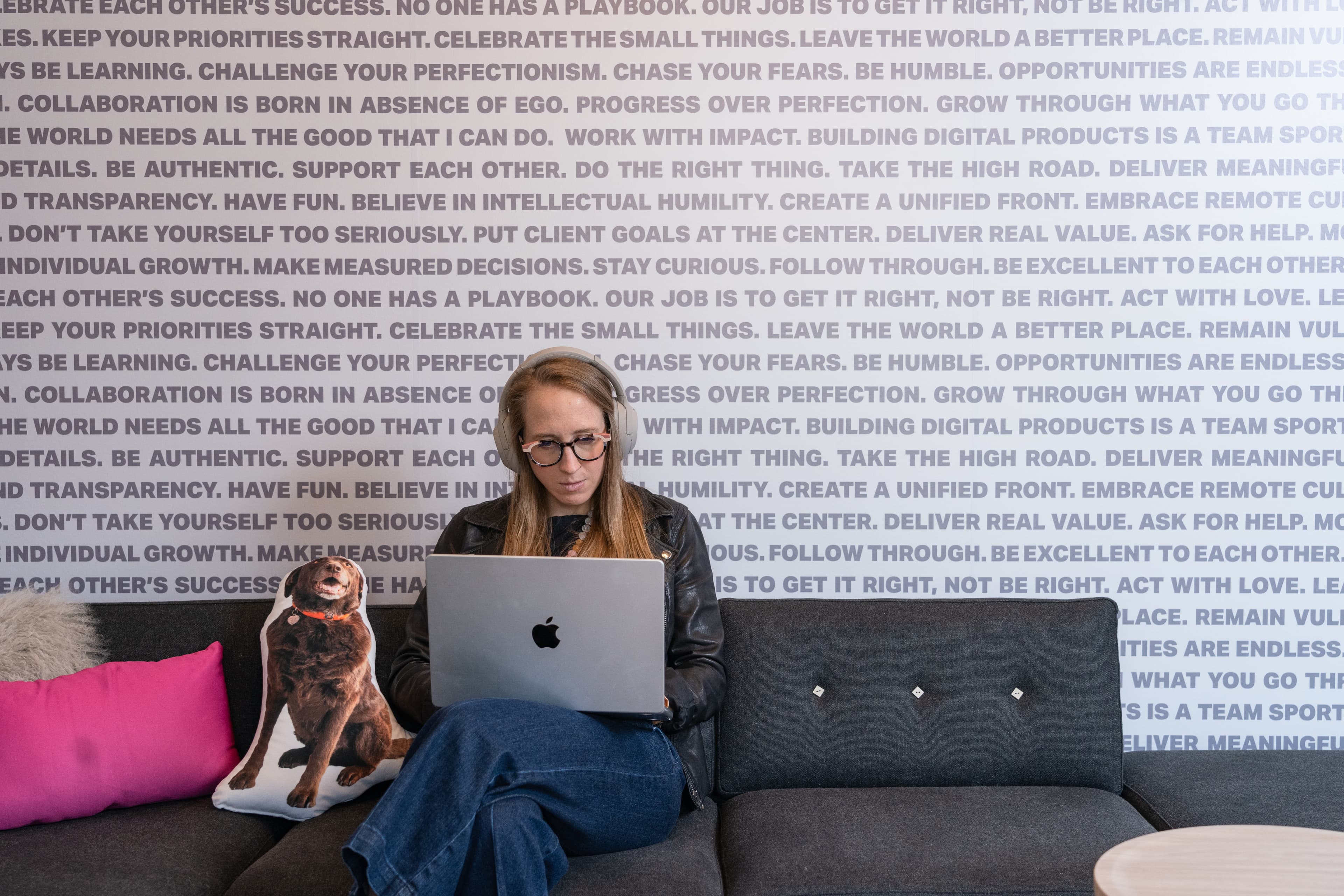 Employee working on laptop next to dog pillow
