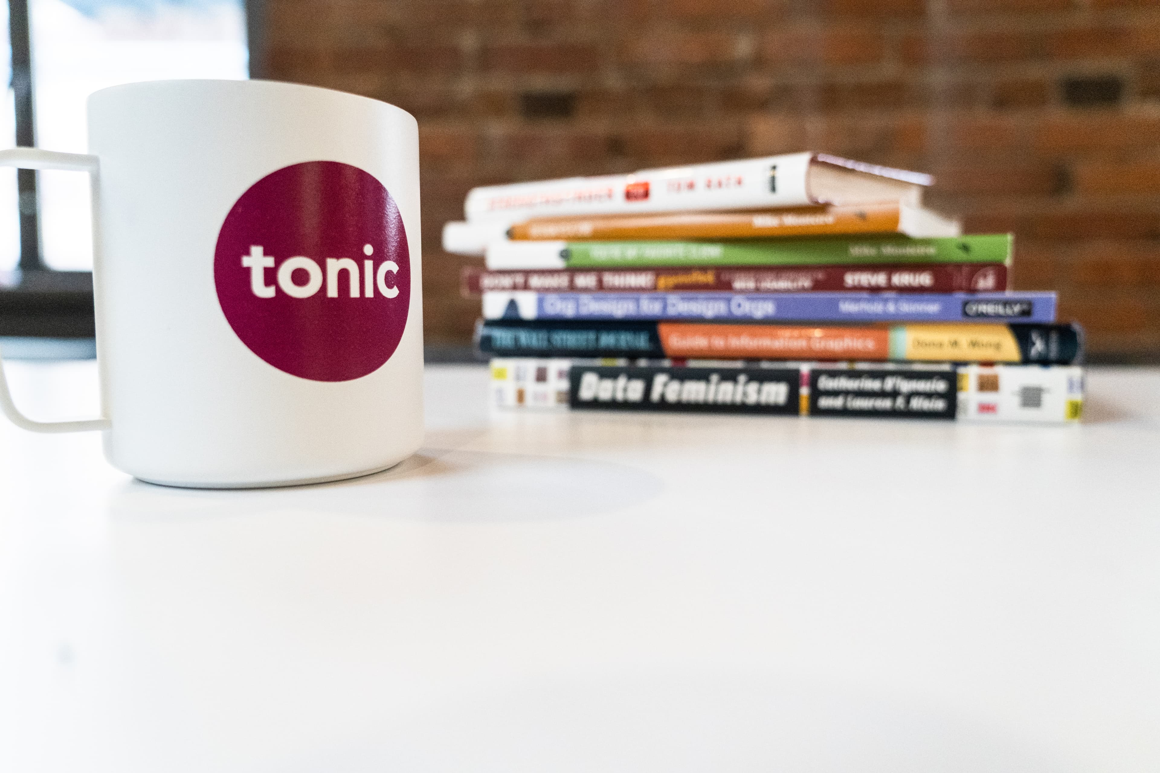 Stack of books next to Tonic coffee cup