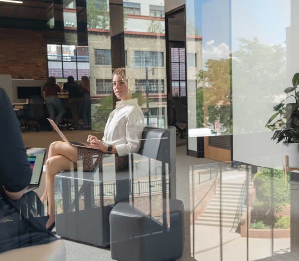 Company leadership at work with courtyard reflections in window