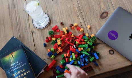 Table with book, cocktail, lego and laptop