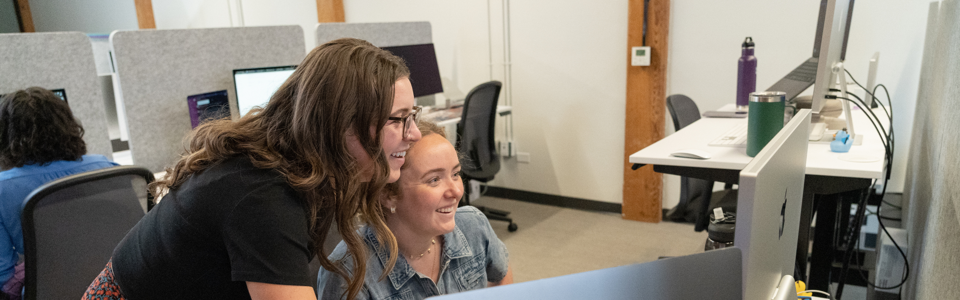 Two Tonic team members collaborating and reviewing work together at a desk