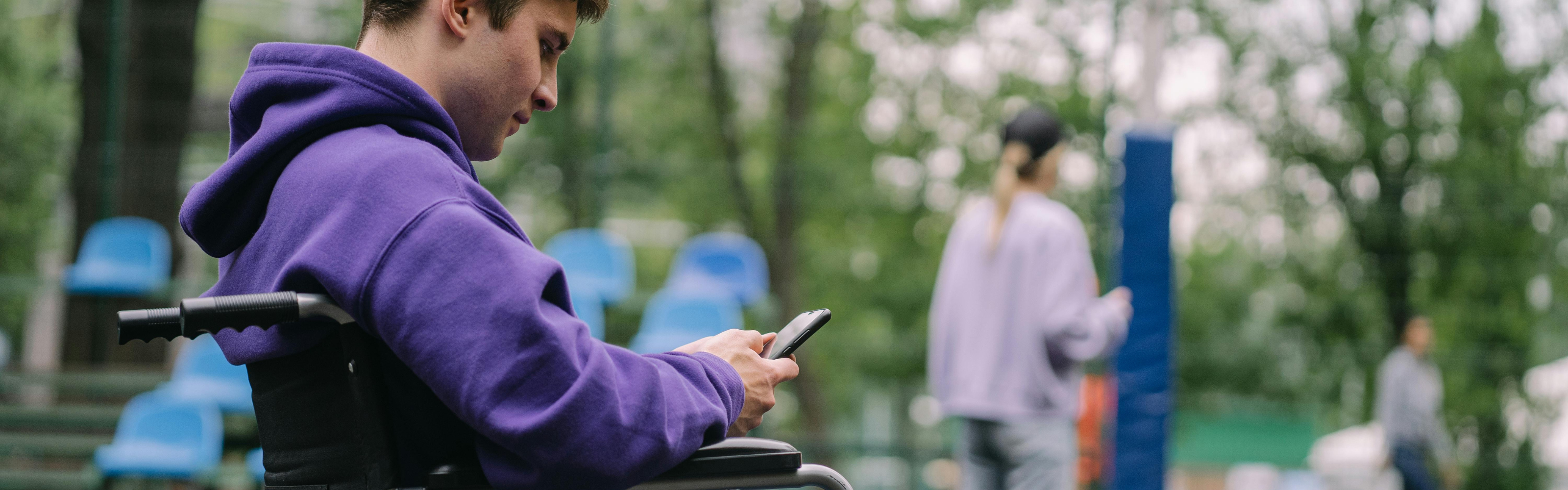 User in a wheelchair on a mobile device